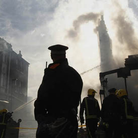 A policeman overlooks destroyed buildings in Tottenham. (Reuters)