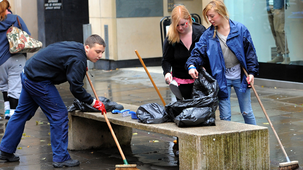 People clean up after the Manchester riots (Getty)