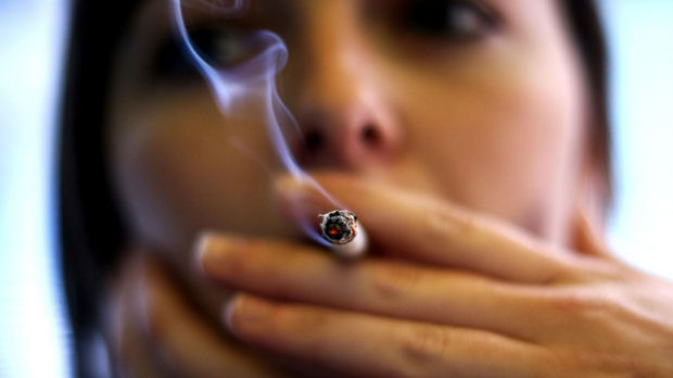 A woman smoking as a study in The Lancet finds that female smokers are more at risk of developing coronary heart disease than their male counterparts (Reuters)