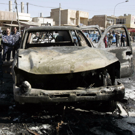 Iraqi policemen inspect the site of a bomb attack in central Kirkuk, 250 km (155 miles) north of Baghdad (Reuters)