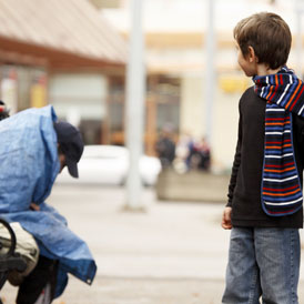 A boy looks back at a homeless man (Getty)