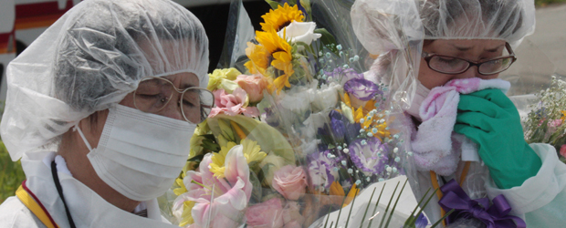 Former residents of the town of Okuma near the stricken Fukushima Daiichi nuclear power plant wipe away tears during a memorial service for the victims of the quake and tsunami (Getty)
