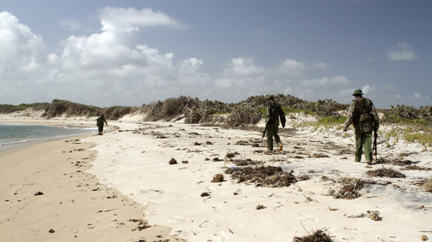 Kenya police officers patrol along the beach at Kiwayu Safari Village resort (Reuters)