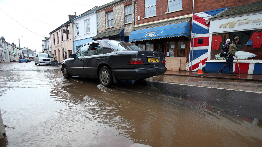 A car drives through flood waters in the centre of the Devon town of Braunton. (Getty)