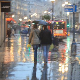 A couple walks down a rainy shopping street in London (Getty)