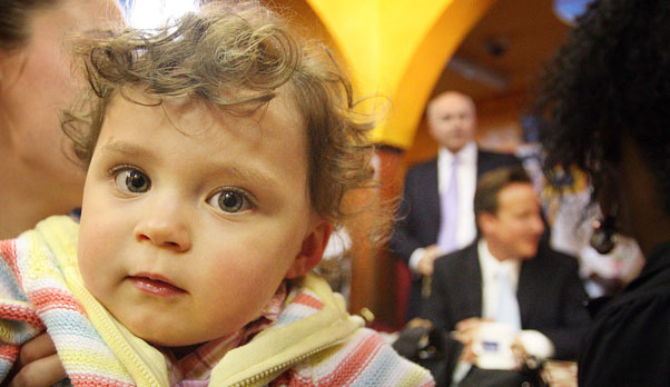 A child in a London nursery with Iain Duncan Smith and David Cameron in background (Getty)