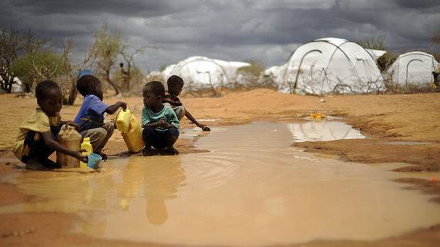 Children playing in a puddle in Dadaab refugee camp Kenya (Getty)