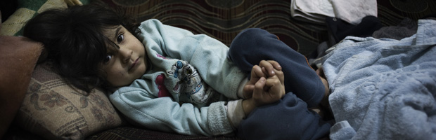 Fatima lies in a room in a house in Lebanon. She fled with her family from the Syrian town of Rastan. (ALESSIO ROMENZI/Save the Children)