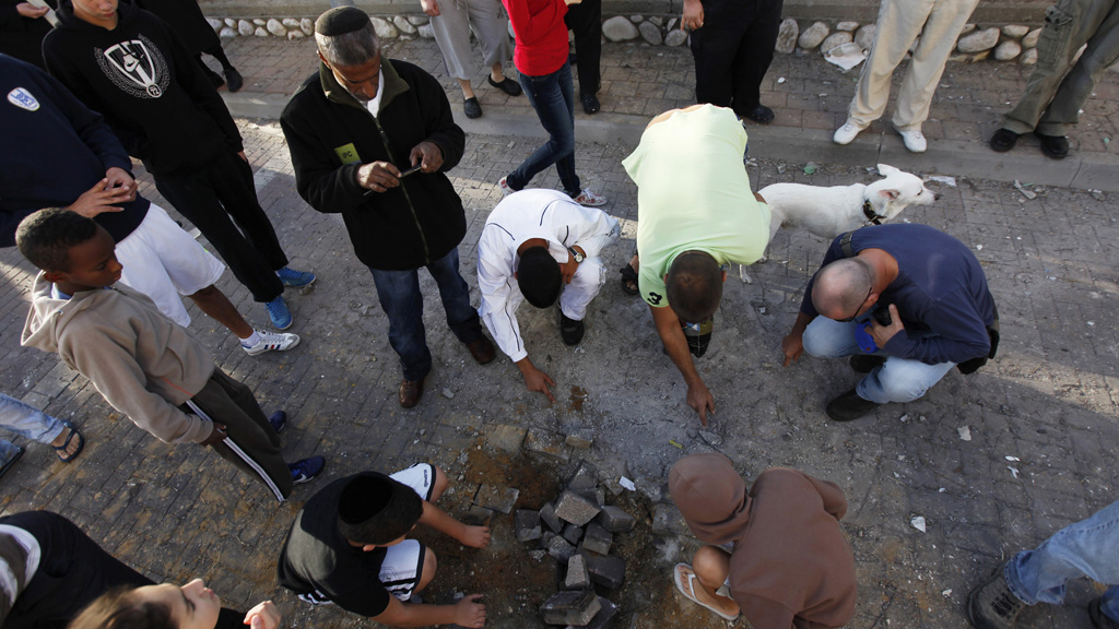Israelis survey damage from a rocket that hit the southern city of Ashod (Reuters)