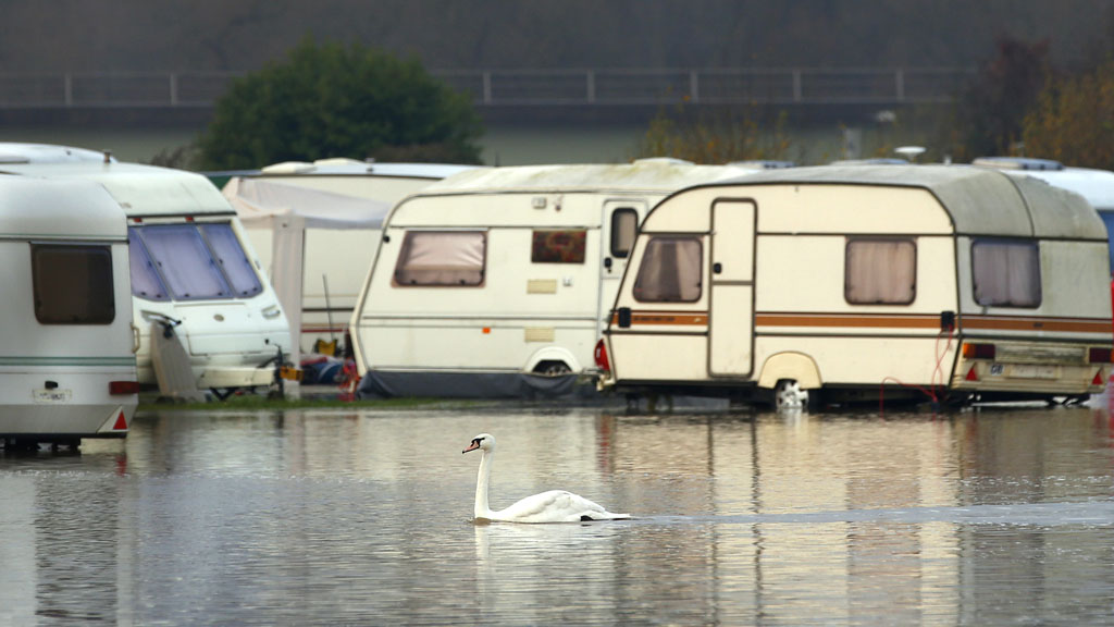 A swan swims through flood waters from the River Soar at a caravan park in Barrow Upon Soar (Reuters)