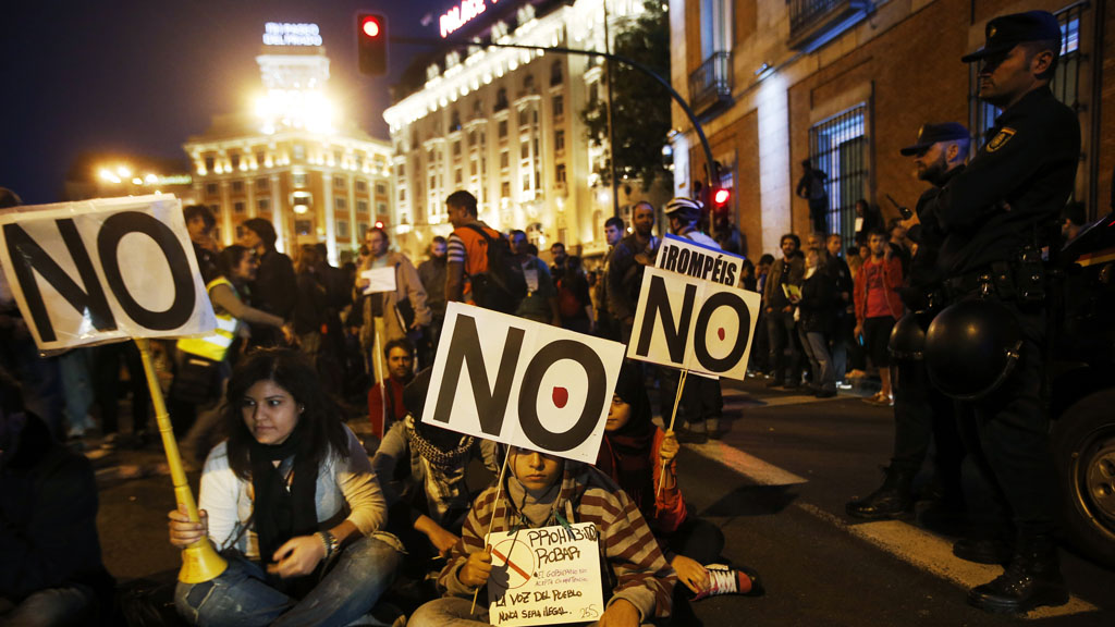 Protesters take part in a sit-in during a demonstration outside Madrid's Parliament (Reuters)