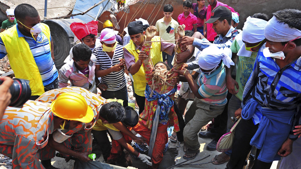 Rescue workers pull a survivor of the building collaopse in Dhaka from the wreckage (picture: Reuters)