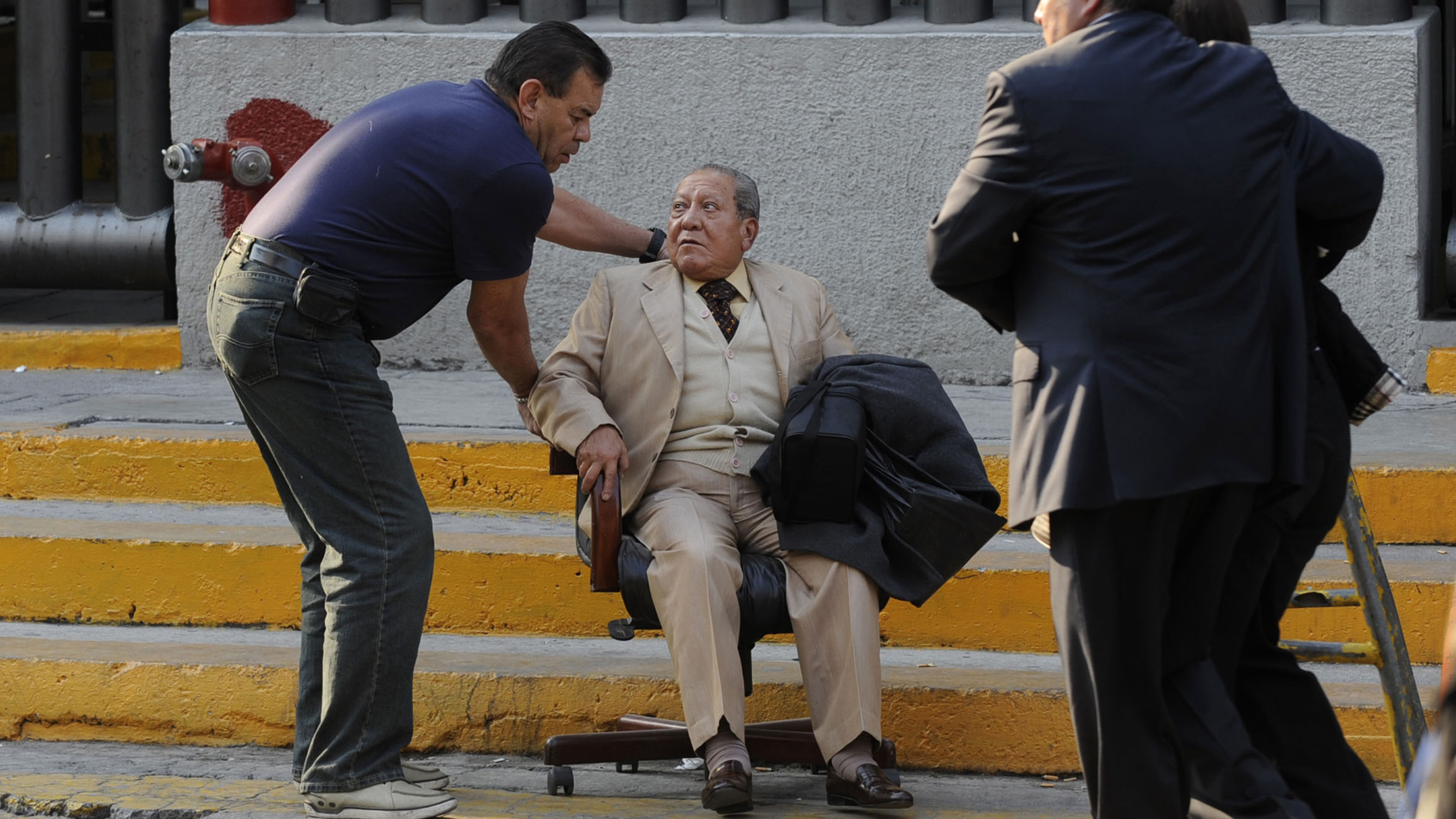 An elderly man is helped outside the Pemex building (Reuters)