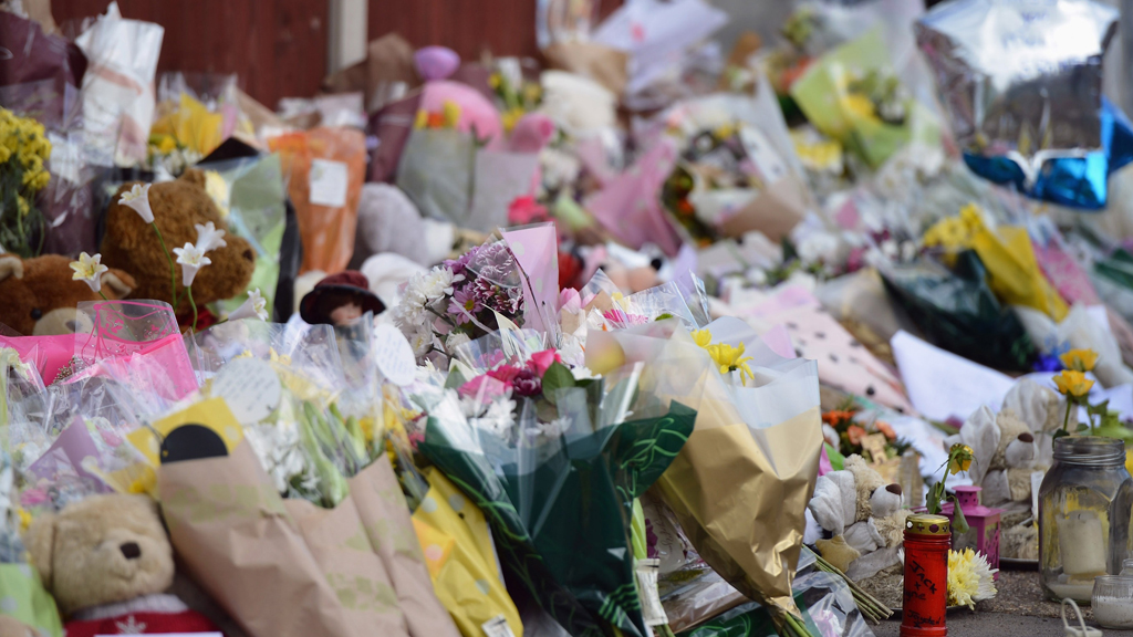 Floral tributes adorn the pavement outside a house in Allenton after a fire claimed the lives of six children (Getty)