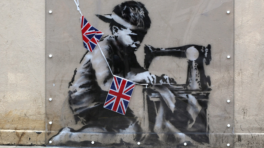 Slave Labour, which shows a young boy hunched over a sewing machine making Union flag bunting (Getty)
