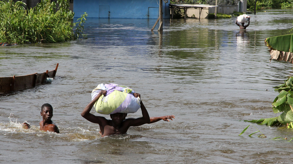 Victims of extreme rain flooding in Nigeria navigate the waters (picture: Reuters)