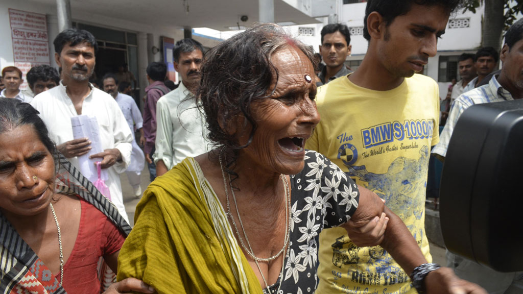 A woman is consoled after her grandson died from eating the meal (R)