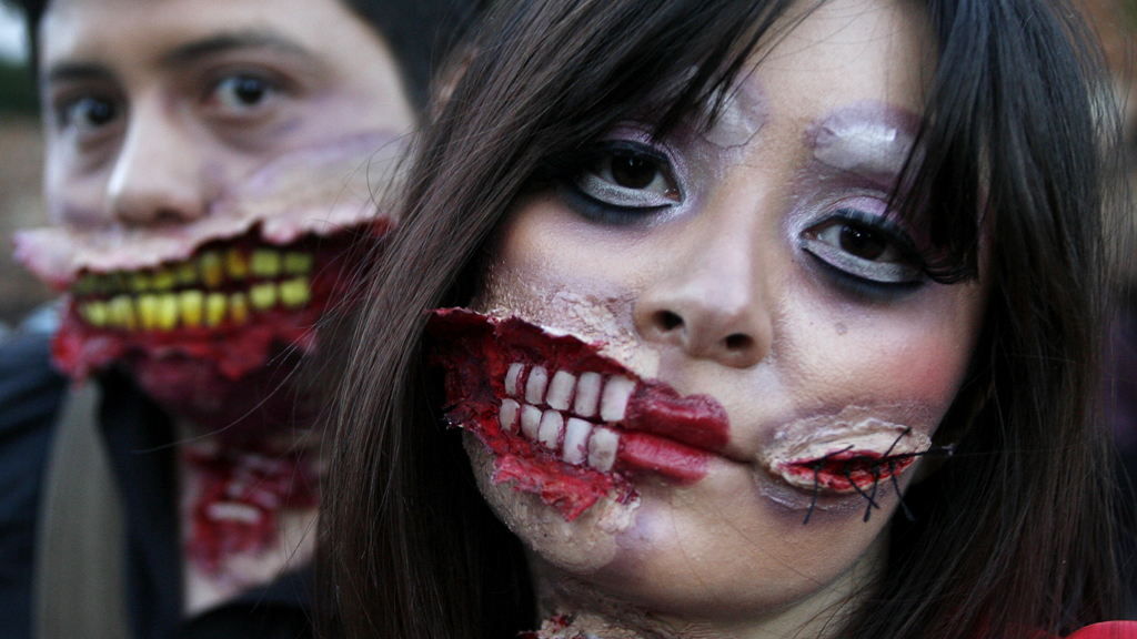 People wear make-up and dress up to take part in a zombie march (R)