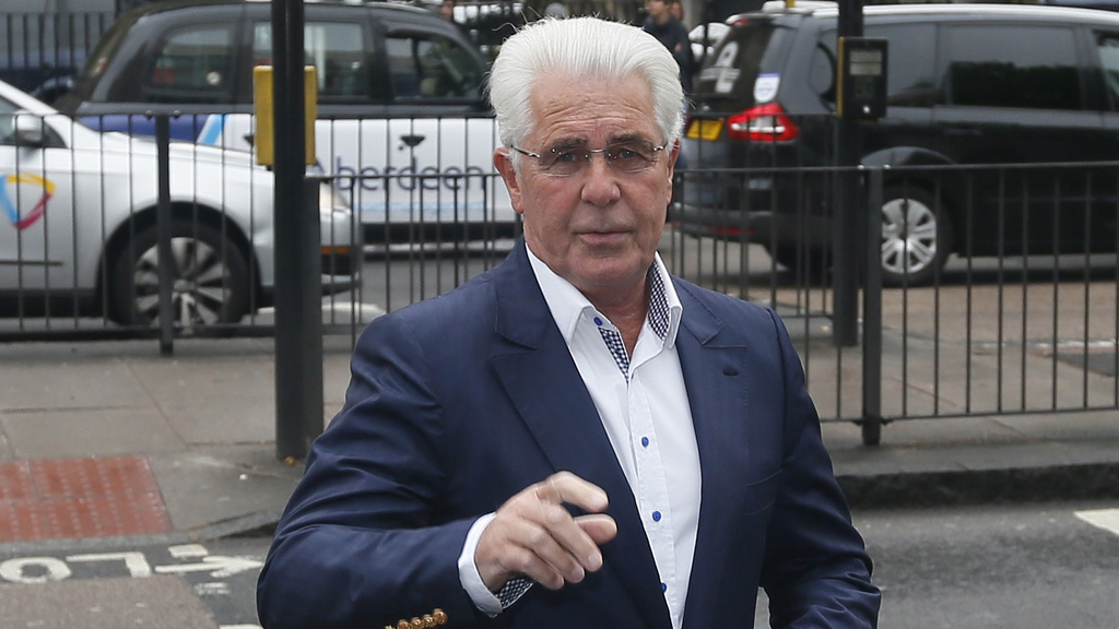 Max Clifford fights his way into court where he denied allegations of historic indecent assault.