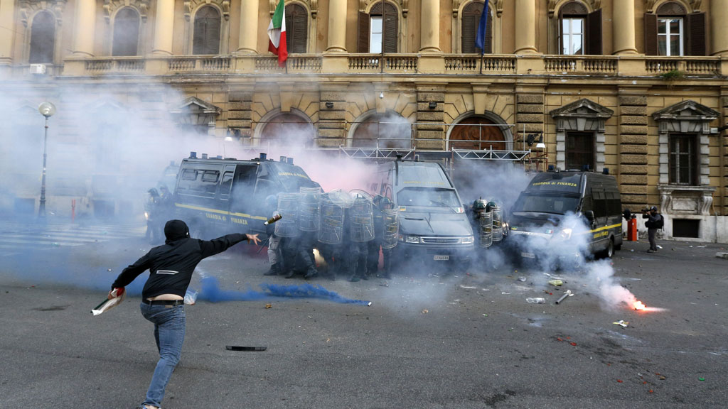 In October a demonstrator throws a bottle at the Guardia di Finanza during a protest in Rome as tensions rise over unemployment (G/R)