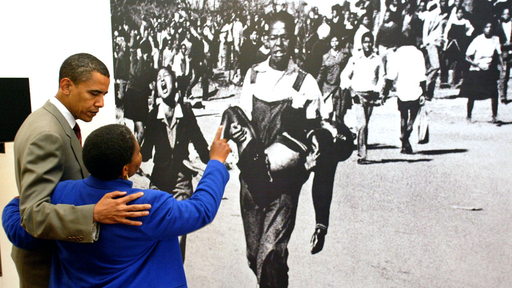 2006: Barack Obama looks at the iconic photo at the Hector Pietersen Museum, Soweto, with Hector's sister (G)