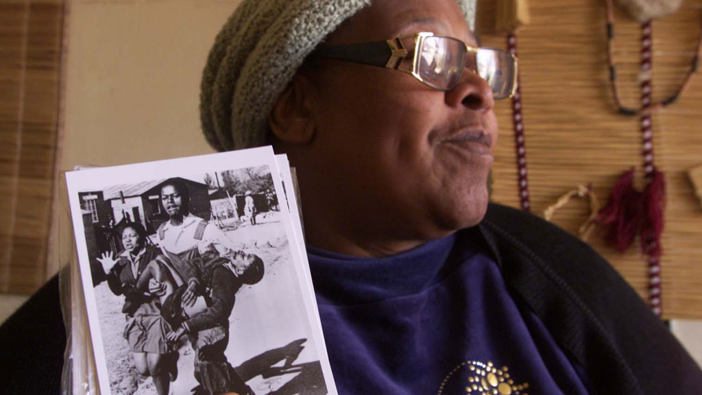2000: Mbuyisa Makhubu's mother Nombulelo holds up a postcard showing her missing son. (G)