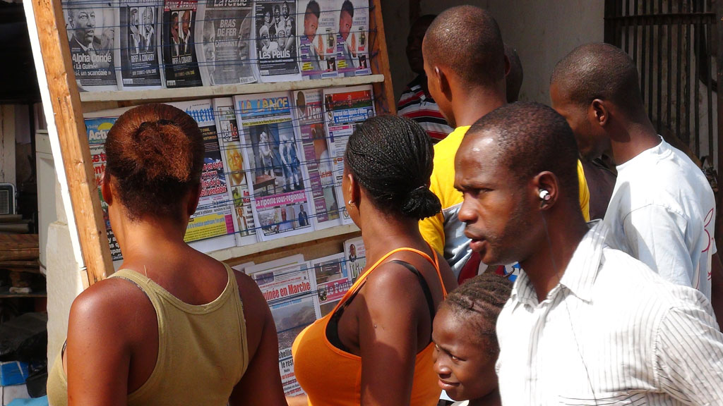 Conakry residents scan headlines (Reuters)