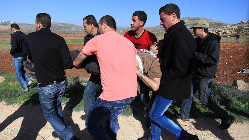 Ziad Abu Ein is carried away by protesters after collapsing