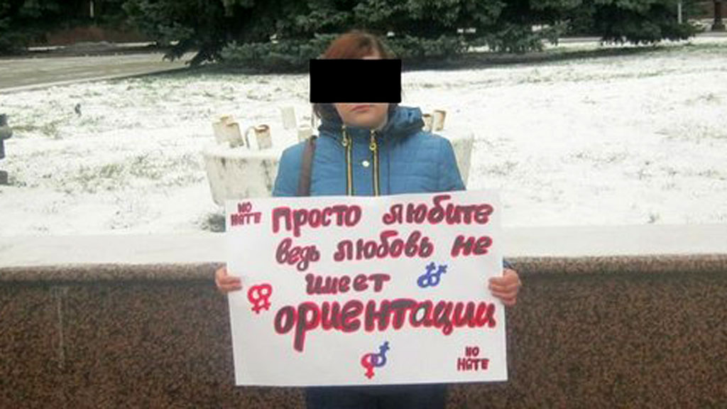 Maria Novikova holding a banner which says 'Just love. Love has no orientation'.