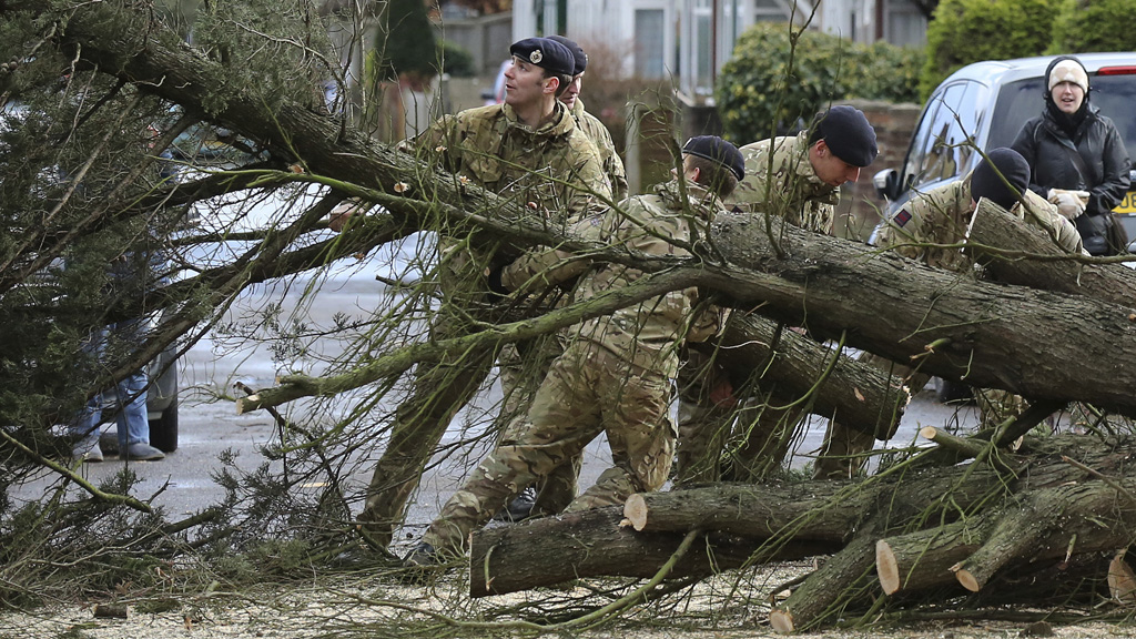 Soldiers helping to clear debris from road (Reuters)