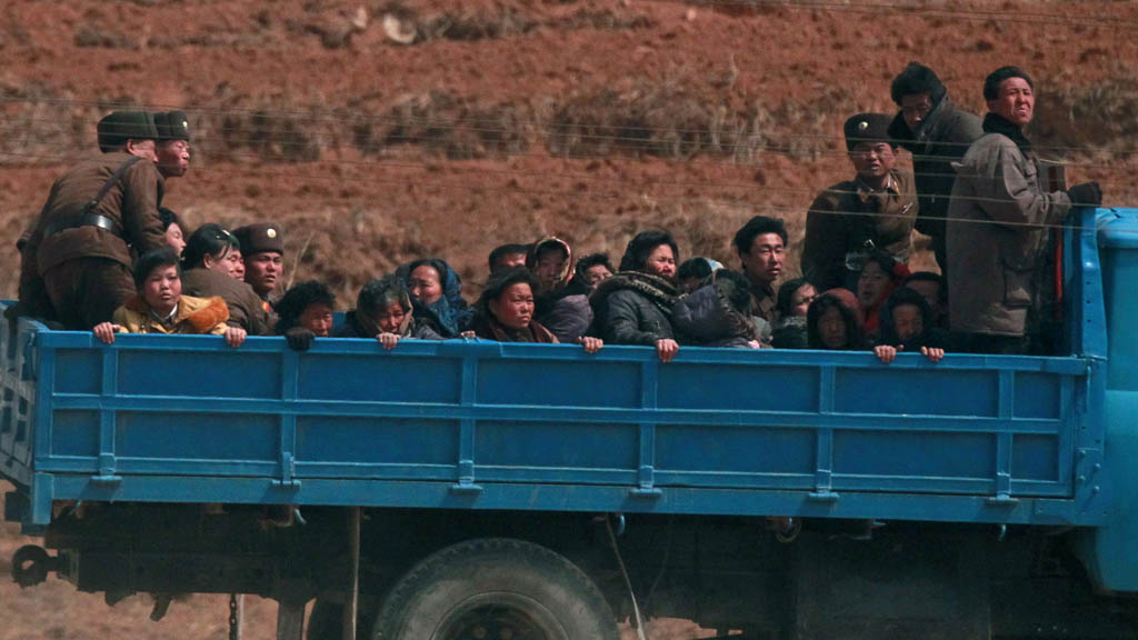 Villagers travel in a truck in a field northwest of Pyongyang