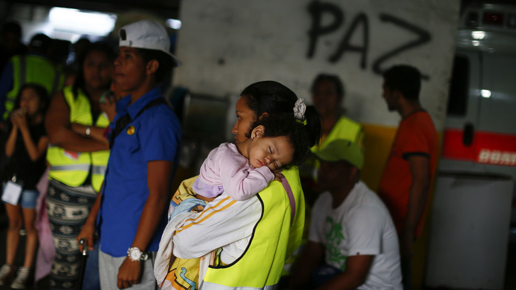 Evicted residents of Tower of David wait for a bus to transport them to their new house in Caracas