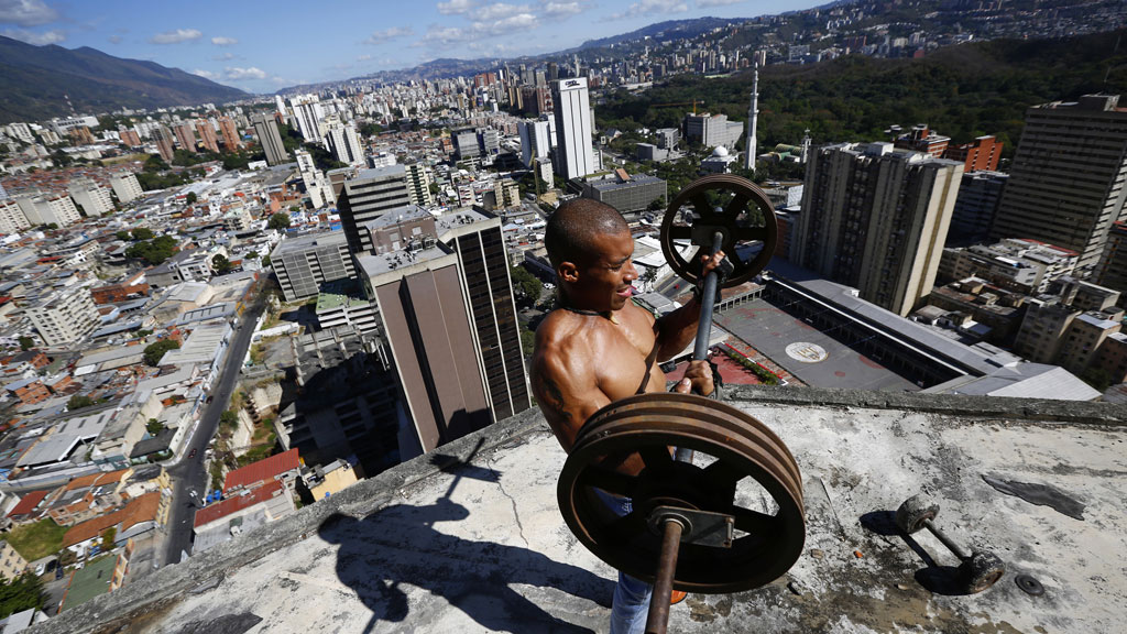 Gabriel Rivas, 30, lifts weights on a balcony on the 28th floor of the 