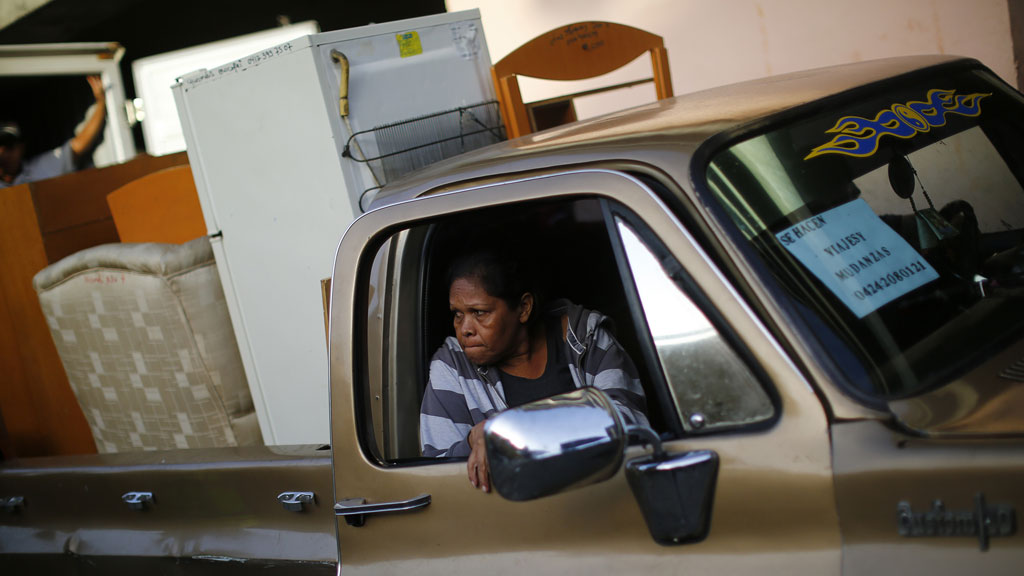 An evicted resident of Tower of David sits in a pick-up truck