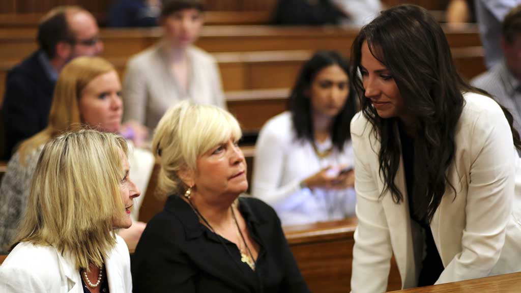 Oscar Pistorius's sister Aimee (right) speaks to Reeva Steenkamp's mother June (left), as her friend Jenny Strydom looks on. (R)