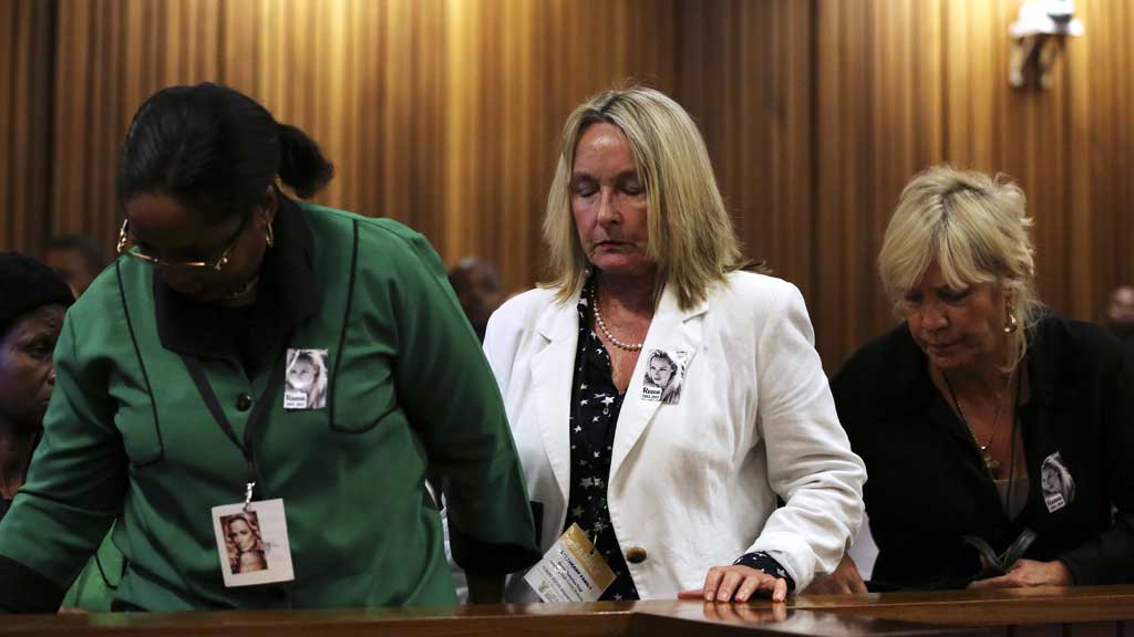 Reeva Steenkamp's mother, June, attends court but leaves during proceedings - accompanied by members of the ANC's women's league - as photos of the crime scene are shown to the trial (R)