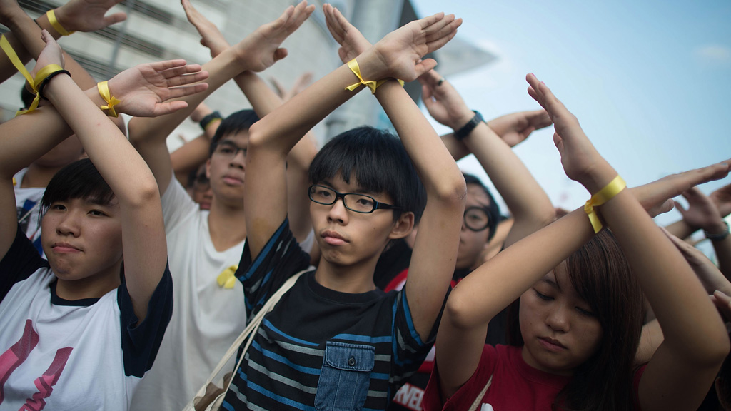 Student pro-democracy group Scholarism convenor Joshua Wong (C) makes a gesture at the Flag Raising Ceremony at Golden Bauhinia Square in Hong Kong
