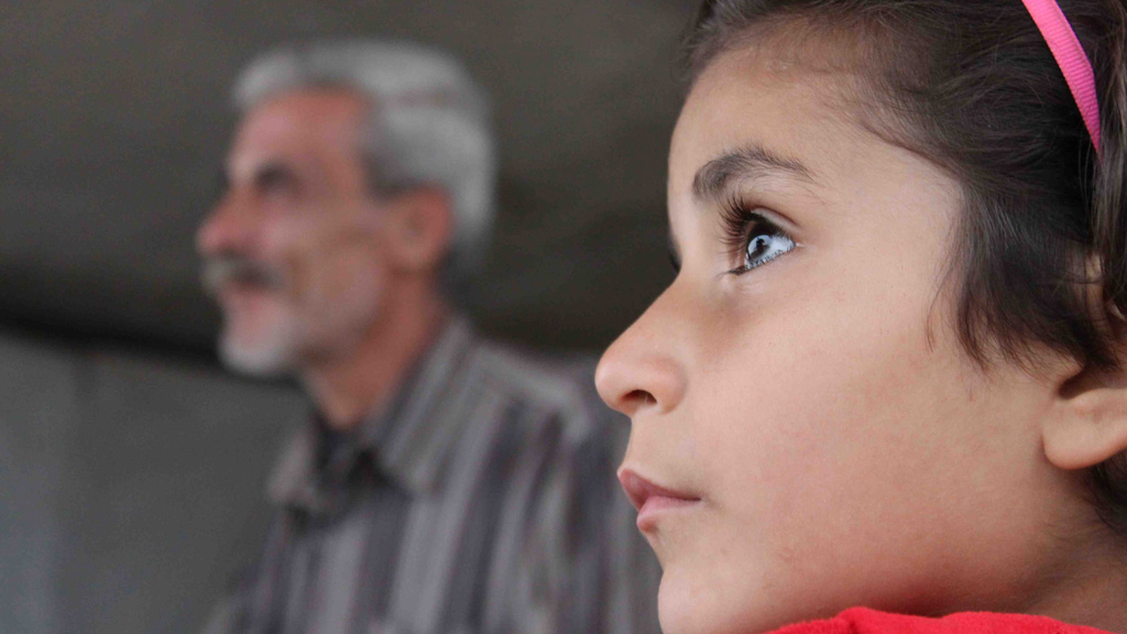 Seven-year-old Israa looks on as her father Mustafa Zakaria Naisa talks to Channel 4 News