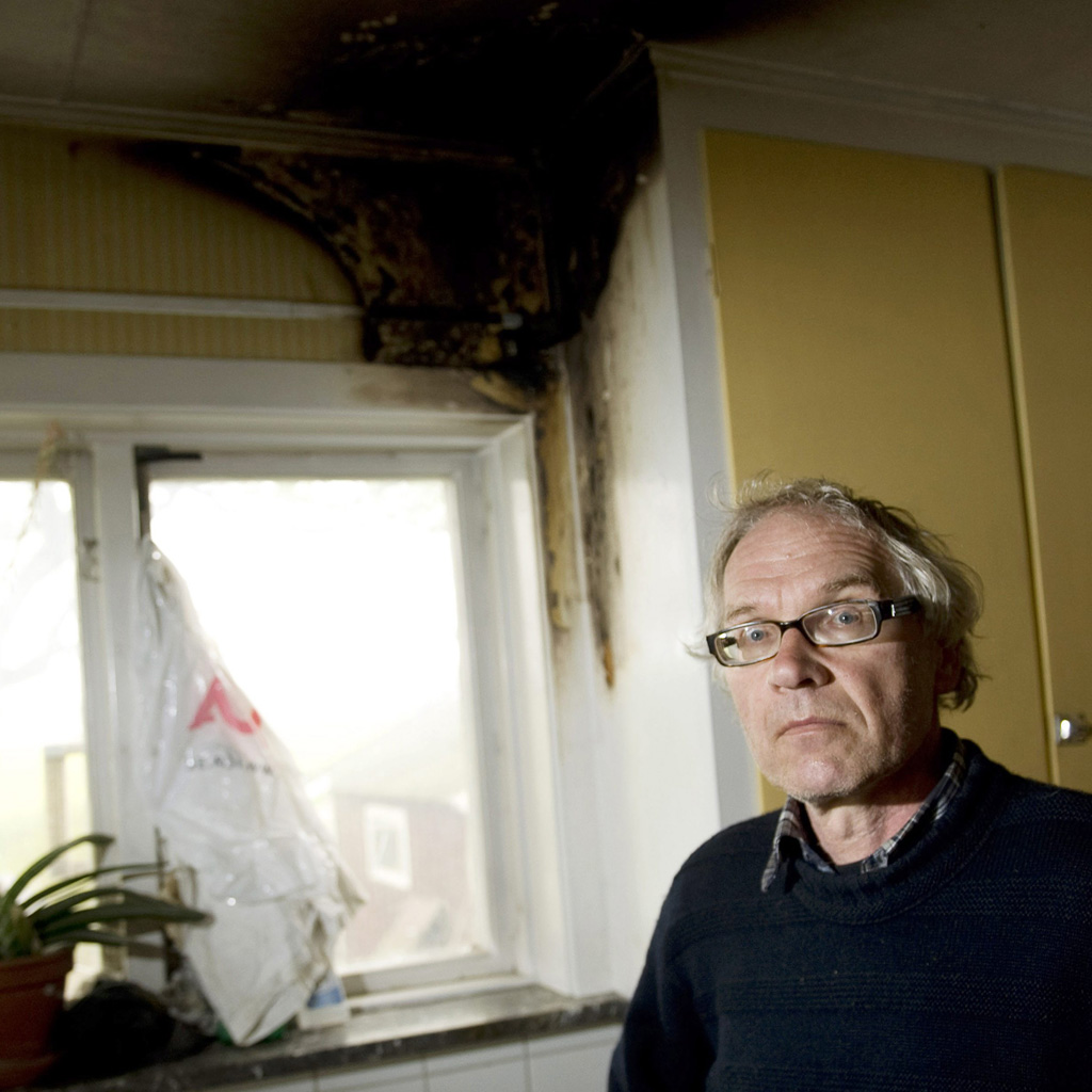 Lars Vilks shows arson damage to his home (Getty)