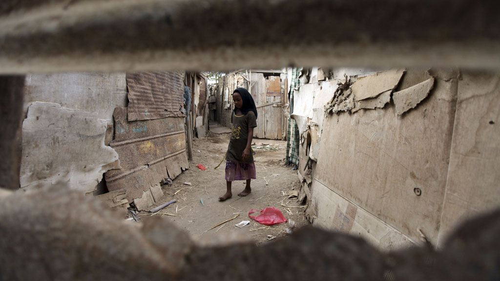 A girl outside her home, made of cardboard and wood, in the slums of Aden, southern Yemen
