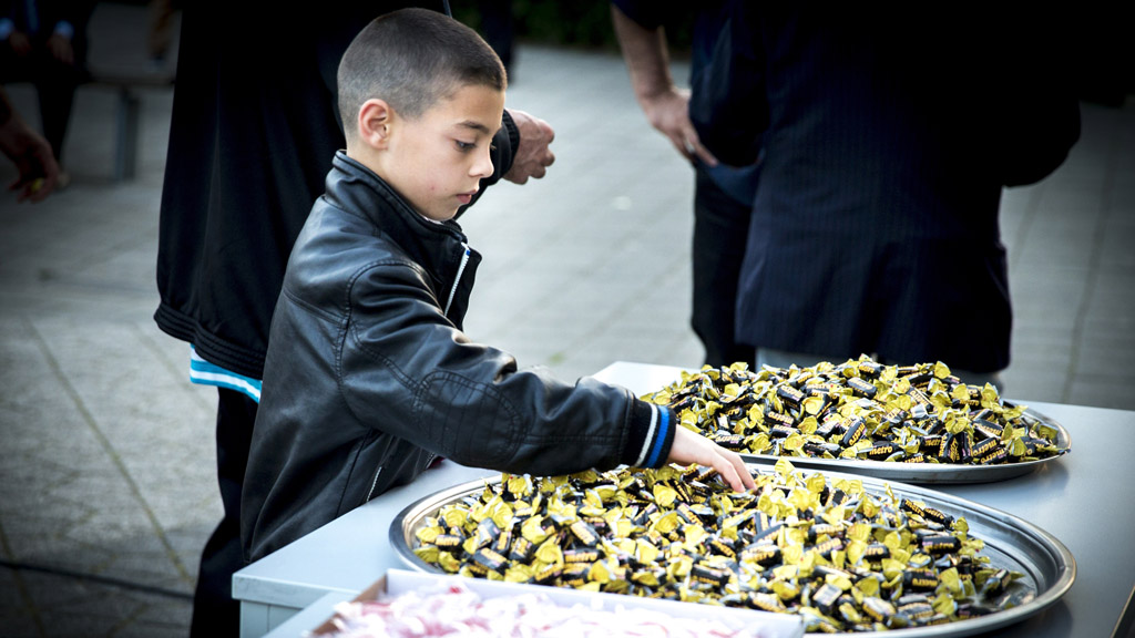 A boy takes a sweet at an Eid celebration in Rotterdam (Getty)