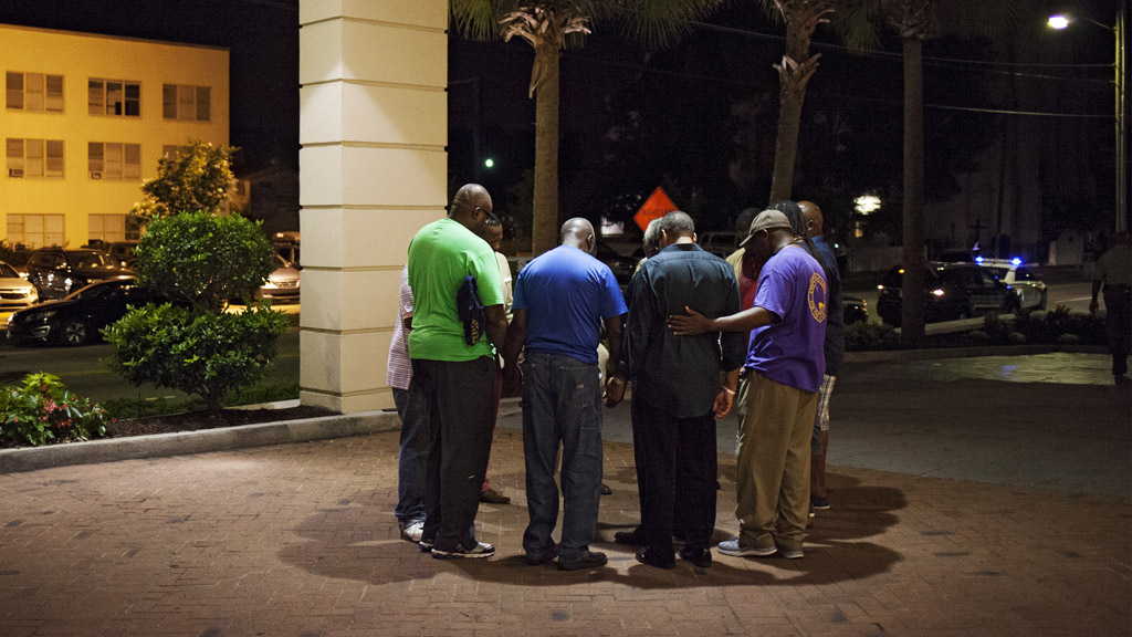 Men gather at a vigil near the church