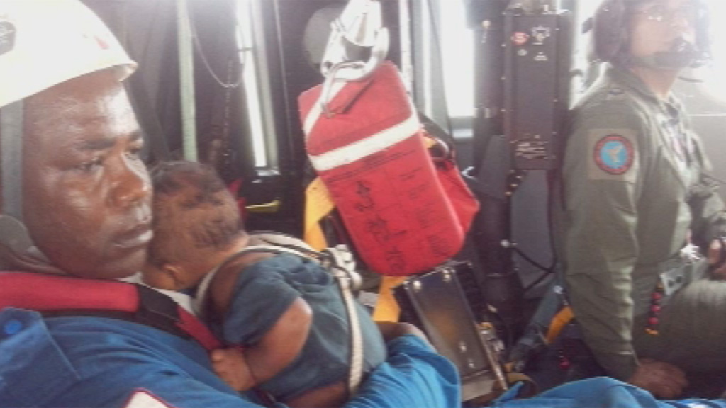 Baby Yudier Moreno in the arms of a rescuer (Colombian Air Force)