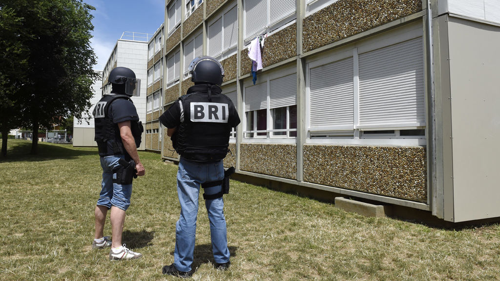 Elite BRI police officers surround the Lyon housing block where suspect Yassine Salhi is believed to have lived (Getty)