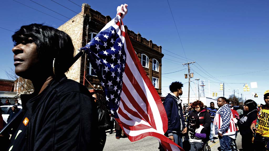 Marchers carry the American flag through Selma (Reuters)