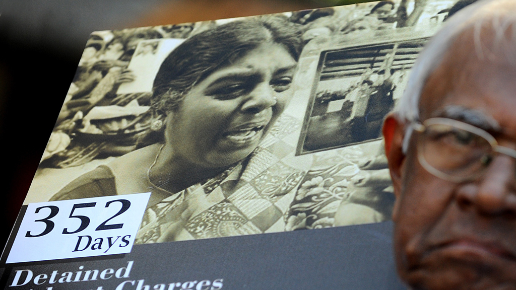 A protester holds a placard showing Jeyakumary Balendaran prior to her release.
