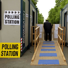 A voter studies the candidates list outside a polling station (Getty)