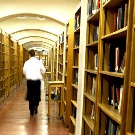 Student walks through university library (Getty)