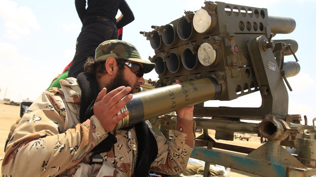 A rebel fighter prepares a Grad multiple rocket launcher on the front line along the western entrance of Ajdabiyah (Reuters)