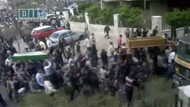 Still image taken from video shows mourners carrying coffins in a location provided as Barzah, Syria